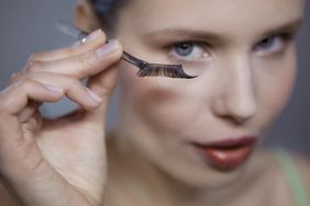 Young adult woman holding false eyelash